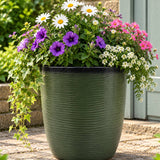 Dark green pot with flowers inside 