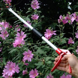 Long handled garden snapper reaching into a bush