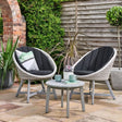 Bistro set 2 egg chairs and one table with cushions set out in a nice garden