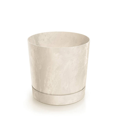 A white plant pot on a white surface outdoors, with one pot containing a green plant.