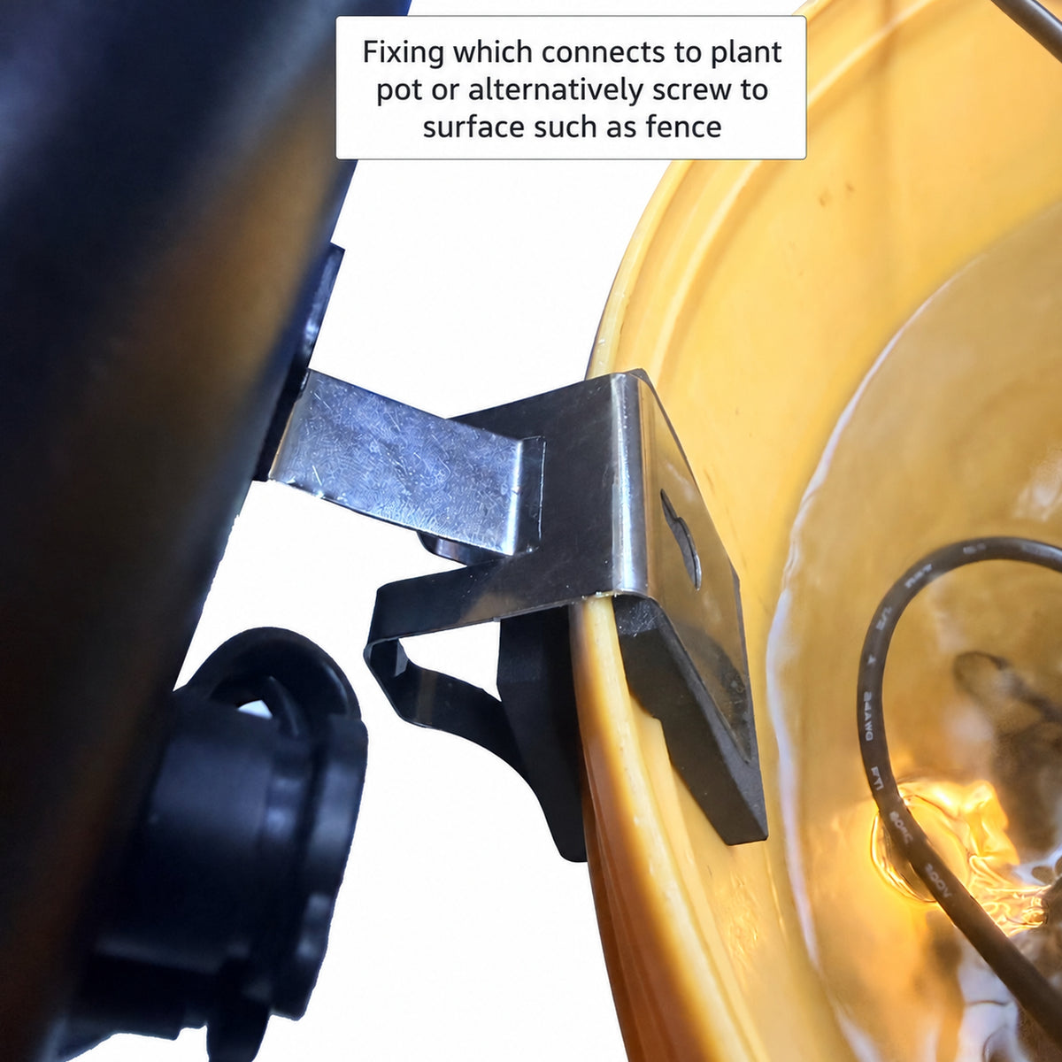 Close-up of a black metal mounting bracket attached to a yellow plastic planter pot, with a text box explaining how the fixture connects to a plant pot or fence.