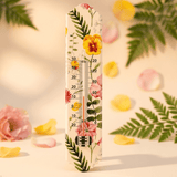 Decorative thermometer with floral design on a soft focus background with flowers and leaves.