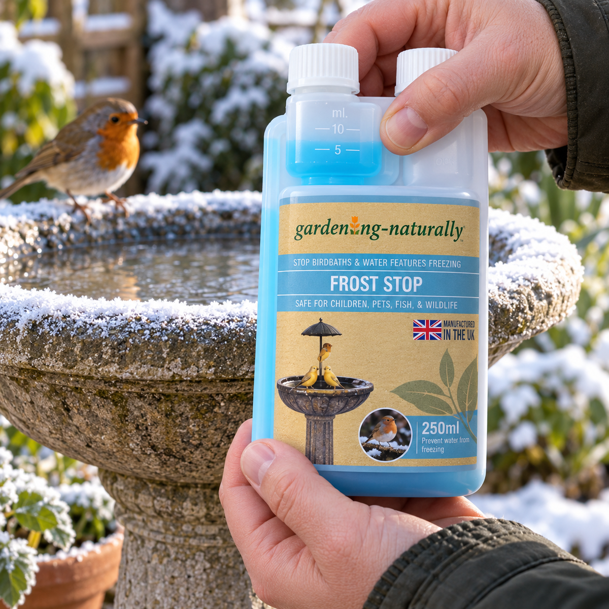 Gardening Naturally Frost Stop 250ml with built-in measuring chamber beside a bird bath and robin in a frosty winter garden.