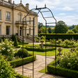 Stately home with a well-maintained garden and metal archway.