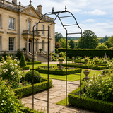Stately home with a well-maintained garden and metal archway.