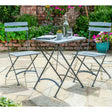 Fold away small table and chairs bistro set in garden with wall and plants