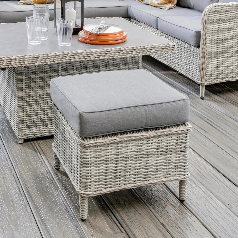 Smalll garden stool with grey cushion on patio with dining set
