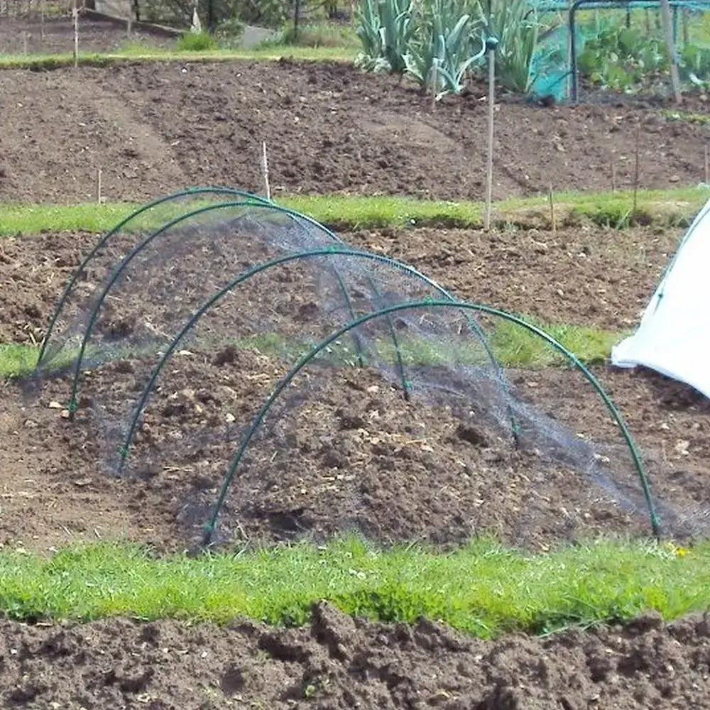 Green garden hoop with netting over a garden bed