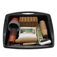A gardening starter kit arranged inside a black plastic tray, including seed starter packs, pots, grow bags, seedling towers, a hand trowel, and a metal scoop, photographed on a white background.