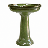 A glossy olive green pedestal birdbath with a flared rim and fluted base, shown against a plain white background.