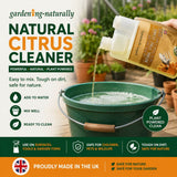 Natural Citrus Cleaner being poured into a green bucket with garden setting in the background
