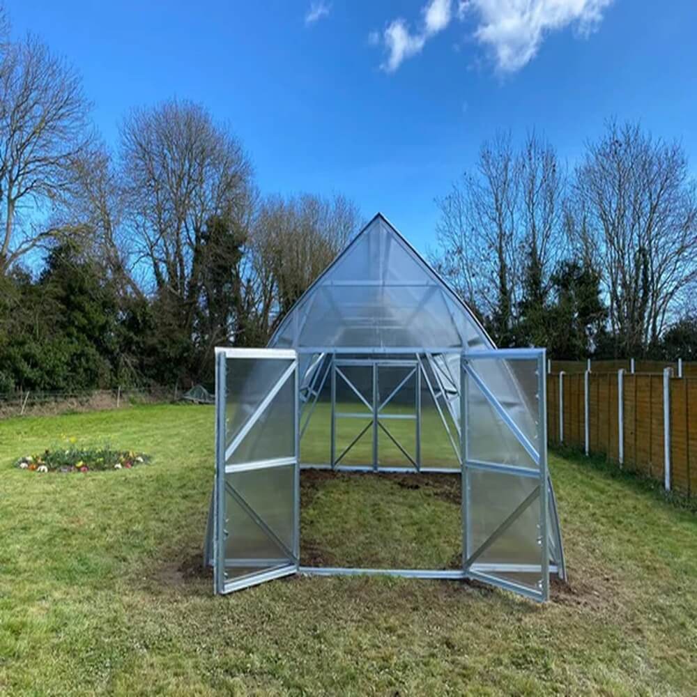large greenhouse in a field with doors open