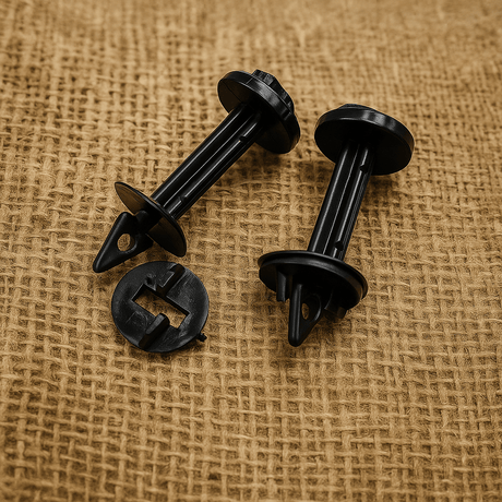 Two black greenhouse plastic clips on a textured brown background