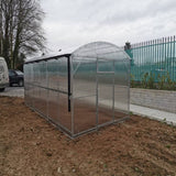 Side view of a greenhouse on a muddy area 