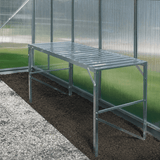 Metal greenhouse frame against a glass wall in a greenhouse setting