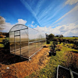 A greenhouse in a field showing the side angle