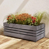Grey wooden planter box with plants on a wooden deck