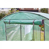 Small greenhouse covered in green plastic, showing door rolled up