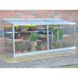 A small half-wall cold frame made of aluminum with reinforced safety glass, containing various potted plants.