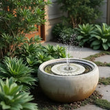 Concrete water fountain with mosaic design in a garden setting
