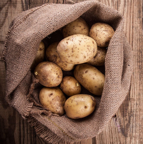 Jute Potato Sack with potatoes in on wooden floor