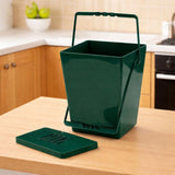 Green kitchen caddy compost bin with a lid on a kitchen counter