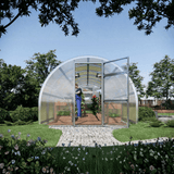 Modern greenhouse with transparent walls and a curved roof in a garden setting.