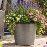 Light grey pot outside with flowers