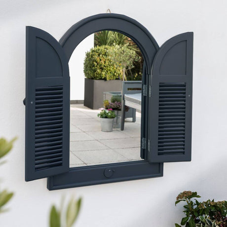 A window with white shutters closed, adding a touch of elegance to the exterior of a house.