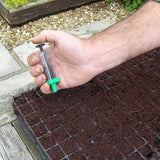 magic seeder tool  in use in someone's hand placing seeds