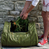 vegetable contents being added to an open green composter sack