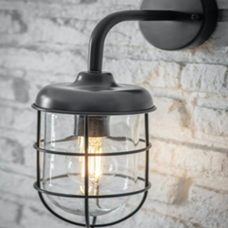 A dark grey garden wall light with a nautical cage design, mounted on a wall with a visible brick pattern.