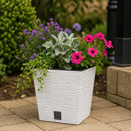 White textured planter with flowers on a patio