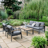 Image of a patio featuring sleek grey furniture and vibrant green plants.