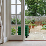 Green wormery stood just outside a house in the garden