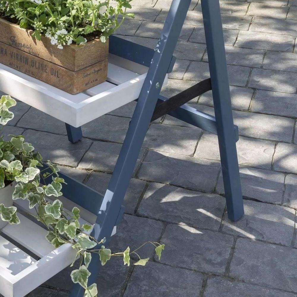 Wooden folding ladder shelf with potted plant.