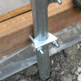 Metal post with a clamp attached to wooden beams on a concrete surface