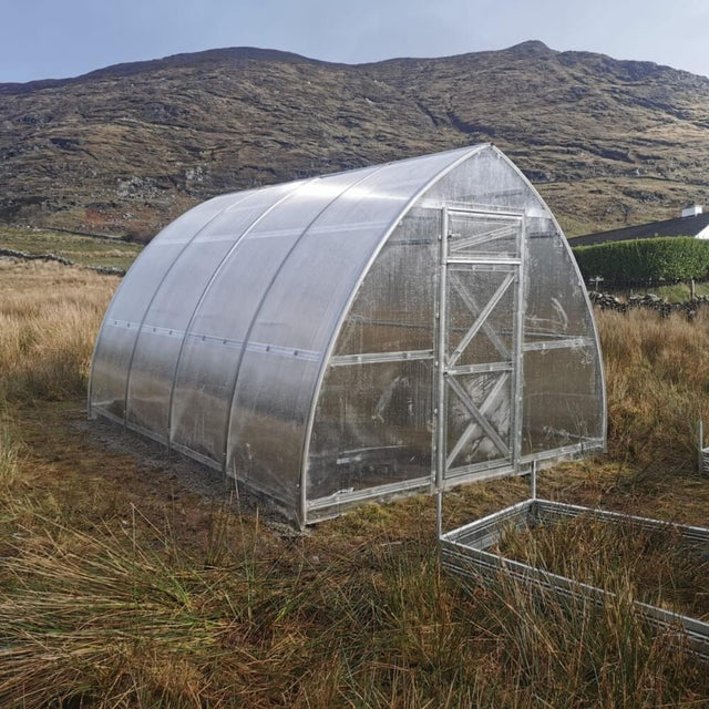 polytunnel greenhouse in front of mountains