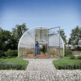 Modular greenhouse with a person inside, surrounded by greenery and flowers.