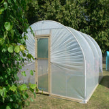 Small greenhouse with transparent covering in a garden setting