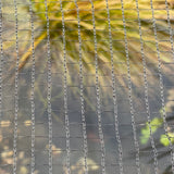 Close-up of black pond netting with a mesh size suitable for protecting fish from cats and birds, and preventing debris from entering the pond.