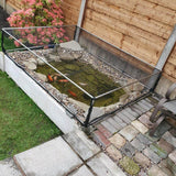 Small garden pond with fish, covered with a pond cage on a patio area.