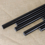 A collection of black powder coated fruit cage aluminium poles of various lengths laid out on a textured fabric surface.