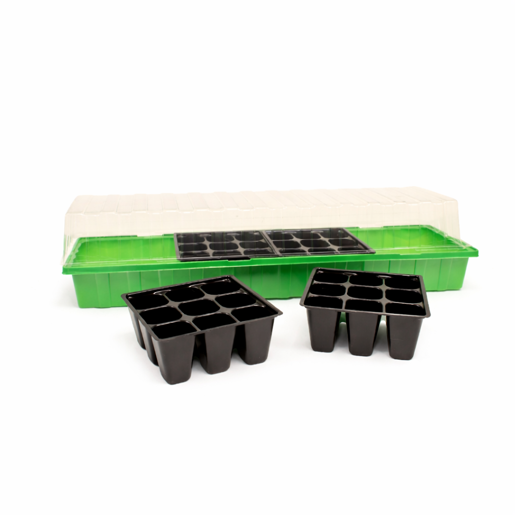 Green seedling tray with black plastic pots on a white background