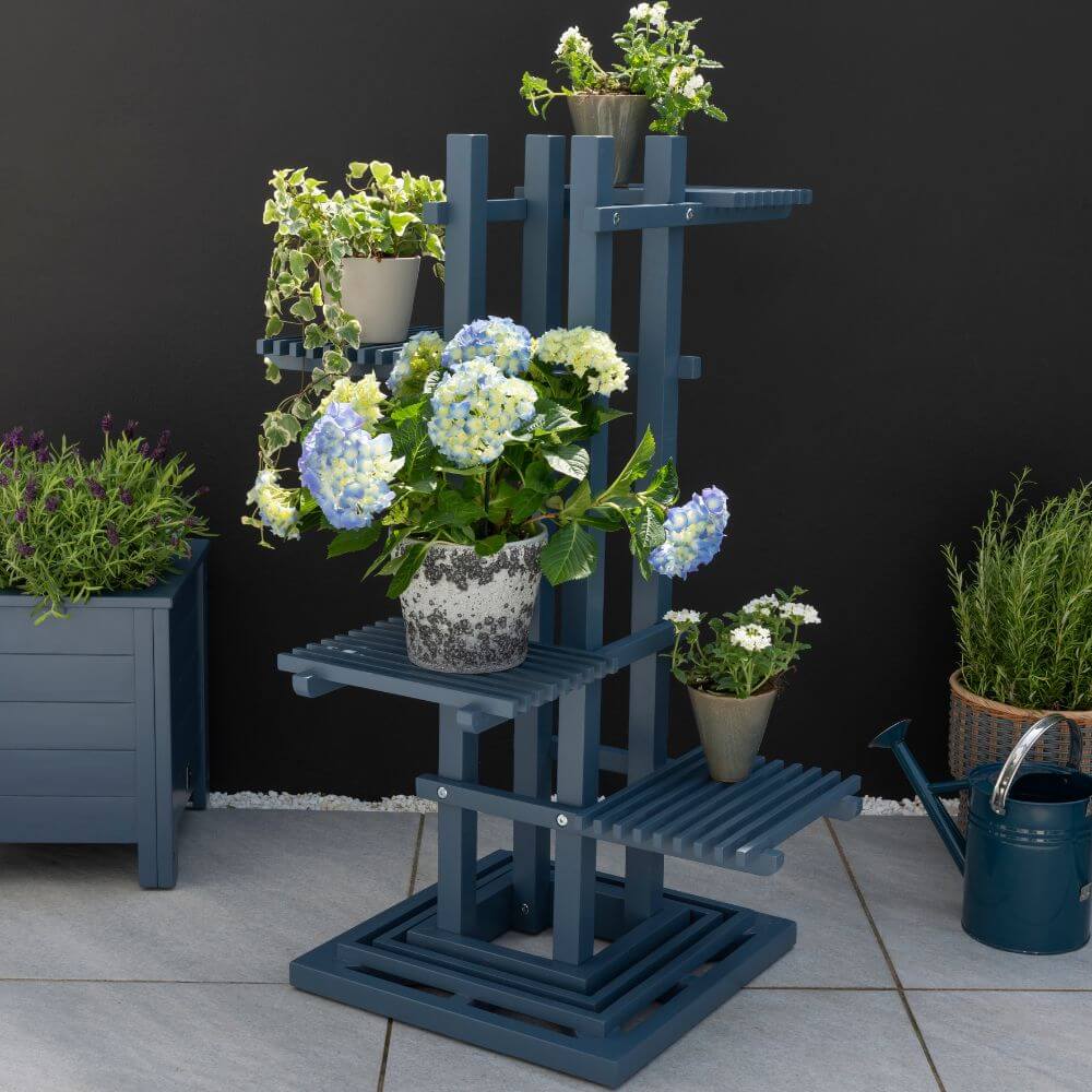 Blue wooden planter with colorful flowers, adding a touch of nature to any outdoor space.
