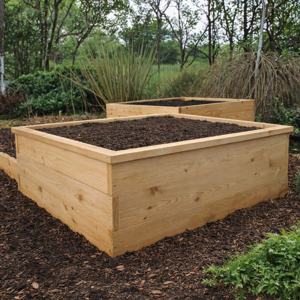 Two wooden raised garden beds in a natural setting with trees and shrubs.