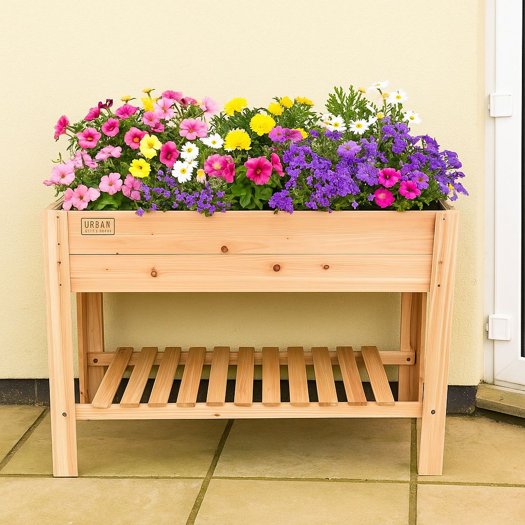 Wooden planter box on legs with colorful flowers on a tiled floor.