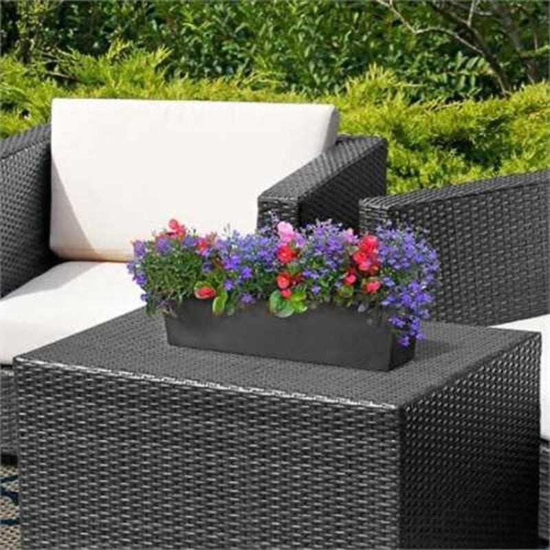 Rubber window box with flowers sat on coffee table in garden