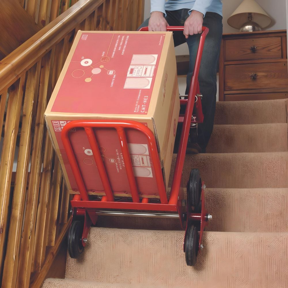 Man using sack truck on stair in a house