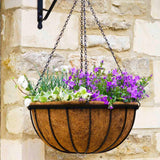 A metal hanging basket with a brown coco liner, purple flowers